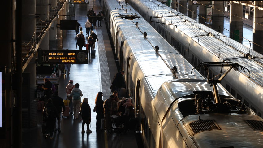 Varios pasajeros se suben a tren AVE con destino Sevilla en la estación de Atocha en Madrid a primera hora de la mañana