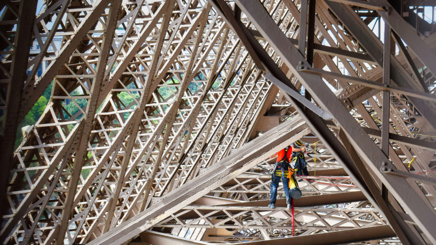 Trabajos de mantenimiento por dos operarios en la estructura metalica de la torre Eiffel en Paris, Francia