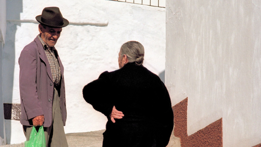 Dos jubilados se detienen a charlar en las empinadas escaleras del pueblo encalado de Torrox, Málaga.