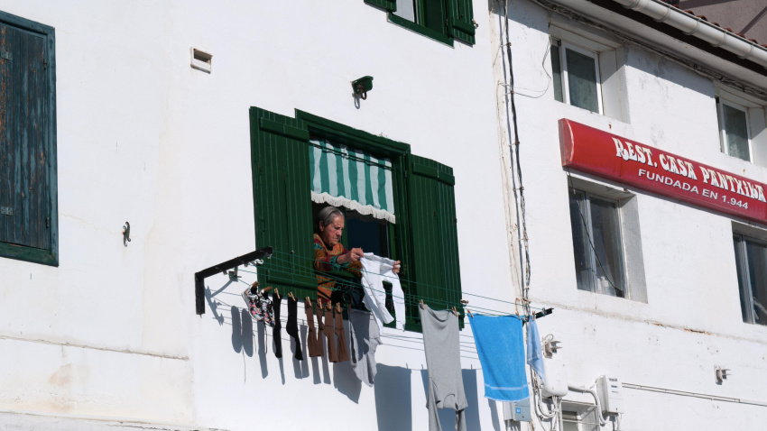 Una anciana colgando la ropa para secarla desde una ventana en la Ciudad Vieja de Donostia San Sebastián, la ciudad costera del Golfo de Vizcaya.