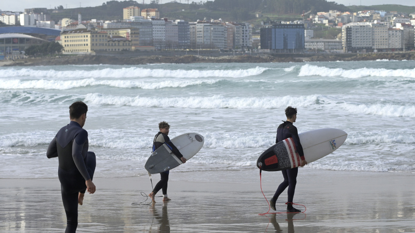 Varios surfistas en una playa de A Coruña un día de temporal