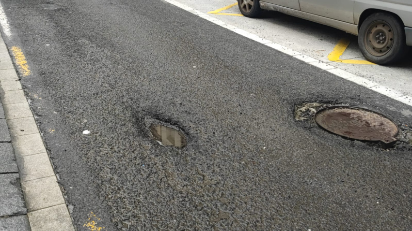Baches y tapas de alcantarilla hundidas en el asfalto