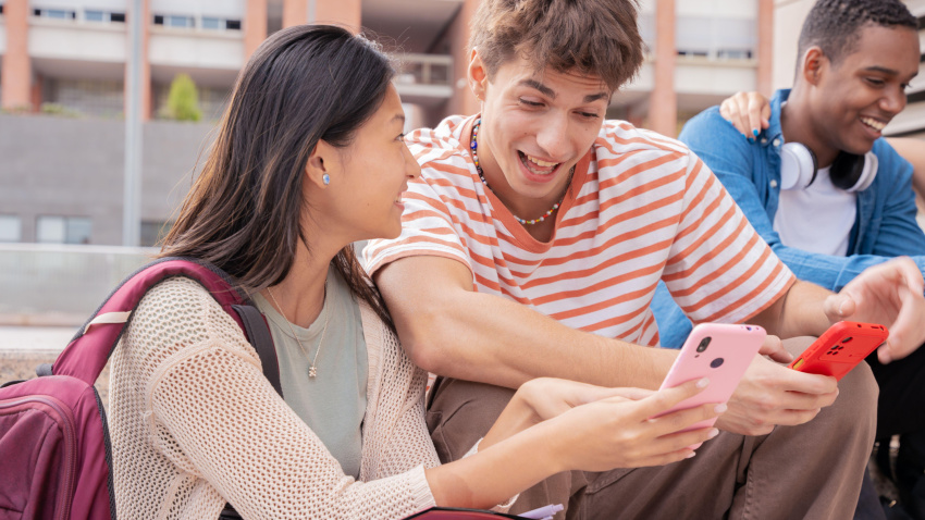 Amigos felices navegando por una aplicación de redes sociales con un smartphone.