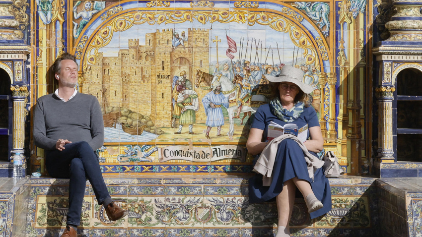 Turistas aprovechan el buen tiempo para tomar el sol en la plaza de España de Sevilla