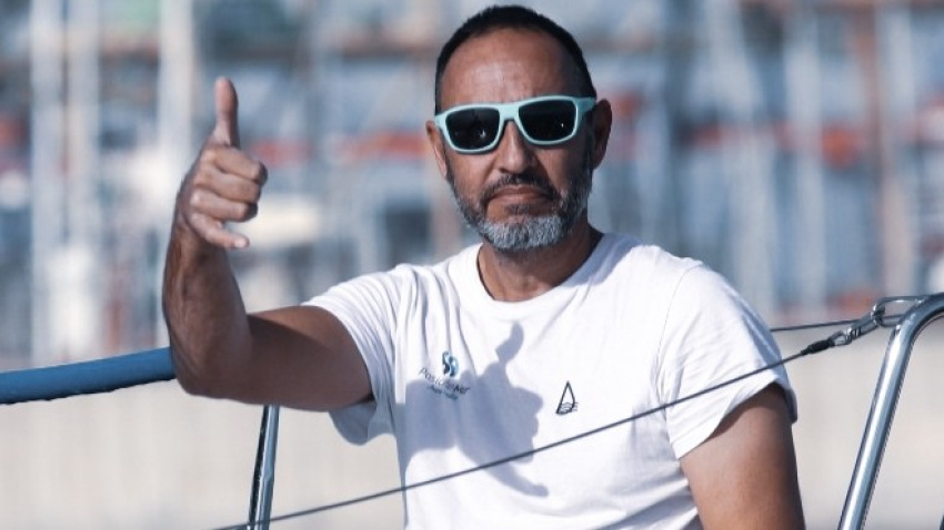 Juan Merediz realizando un saludo desde una embarcación en puerto