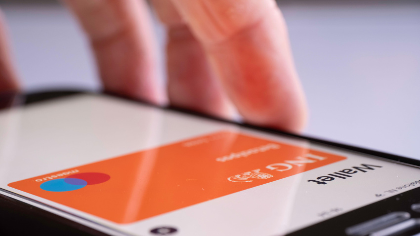 Mano con el iPhone listo para pagar con la cartera Apple Pay