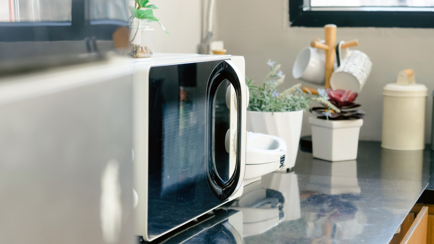 Un microondas descansa en la balda de una cocina