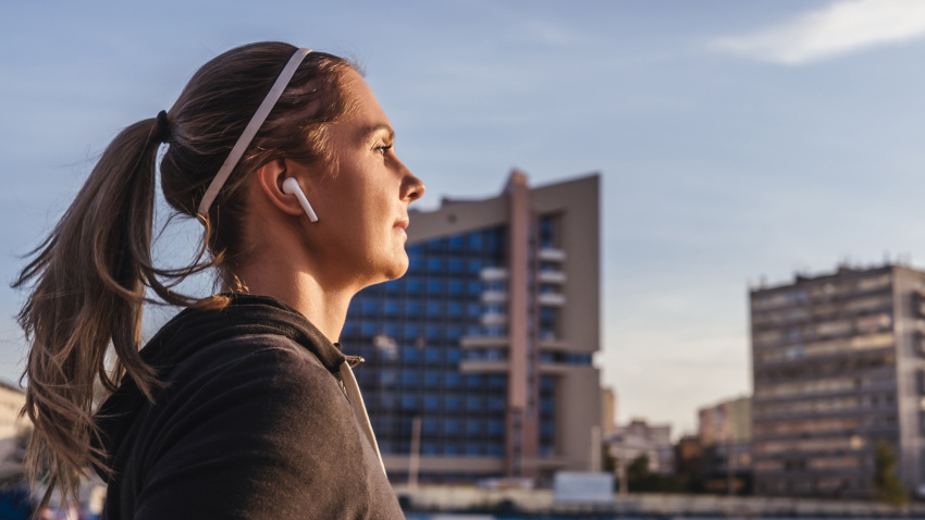 Una deportista escucha música a través de sus auriculares inalámbricos