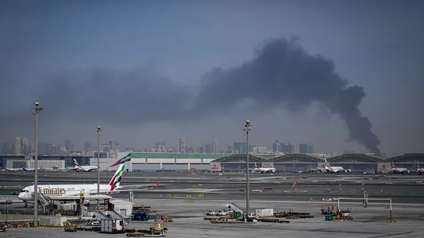 Imagen del Aeropuerto Internacional de Dubai, al fondo una columna de humo fruto de un ataque aéreo.