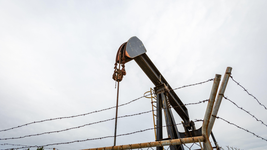Bomba de petróleo en un día nublado y con mal tiempo, con una cerca de alambre