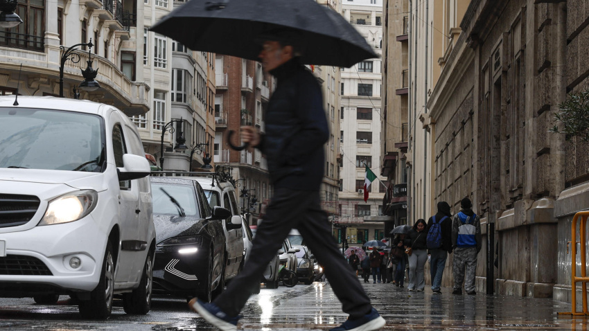 Un hombre camina bajo la lluvia de Valencia