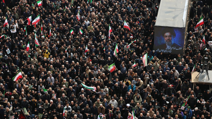 Iraníes se reúnen junto a un cartel del nuevo líder supremo iraní, el ayatolá Mojtaba Jamenei, mientras participan en una ceremonia fúnebre masiva para los comandantes del Cuerpo de la Guardia Revolucionaria de Irán (CGRI), comandantes del ejército y otras víctimas que murieron durante la guerra entre Irán, Estados Unidos e Israel en Teherán.
