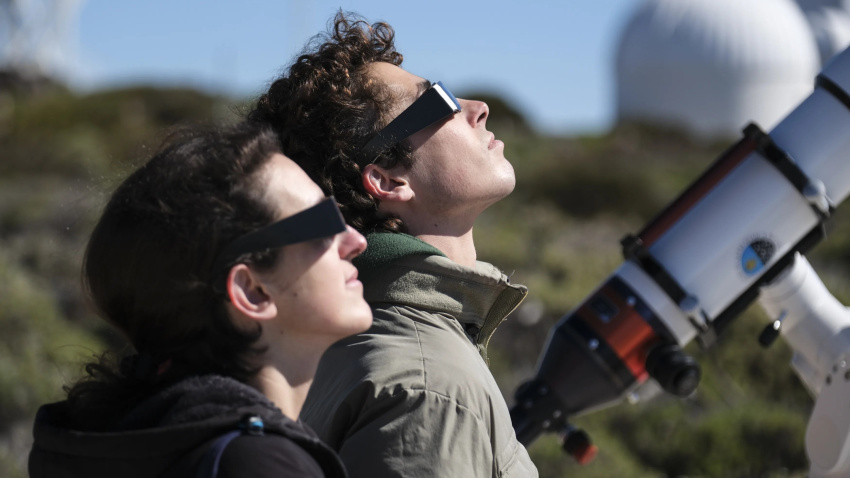 Dos personas mirando un eclipse con unas gafas especiales