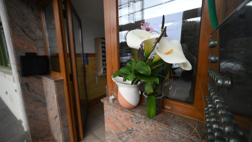 Portal del edificio de Pedreña donde se ha cometido el asesinato machista con unas flores