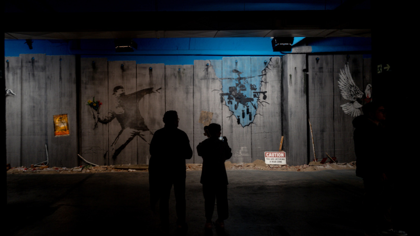 Varias personas recorren la exposición permanente de las obras de Banksy, en el Museo Banksy de Madrid