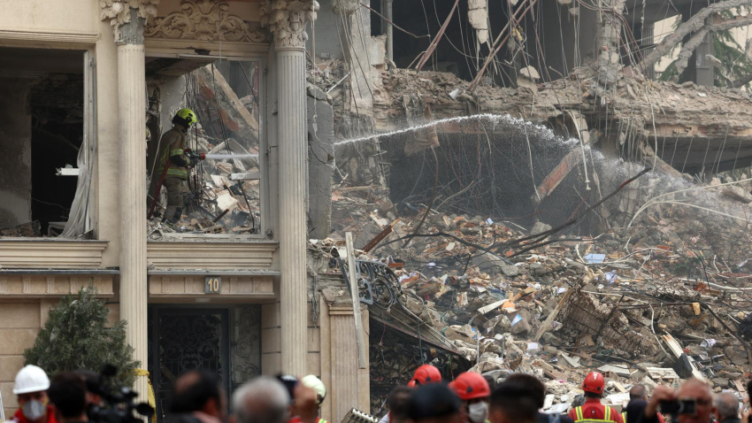 Un grupo de rescatistas trabaja entre los escombros de un edificio que fue atacado por Estados Unidos e Israel esta mañana en el barrio de Andarzgu, en el noreste de Teherán