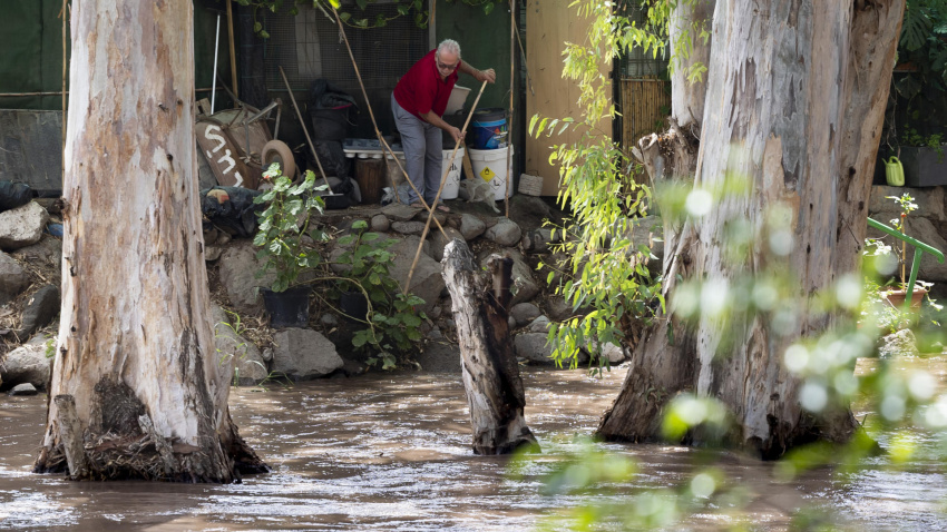 Un vecino del barranco de Arguinegín trata de proteger su vivienda ante la crecida del caudal del barranco