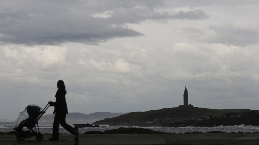 Una mujer camina este martes por el paseo marítimo de A Coruña en una jornada en la que han regresado las lluvias a Galicia tras la llegada de una borrasca desde el Atlántico, junto con una masa de aire frío tras dos días de tiempo cálido