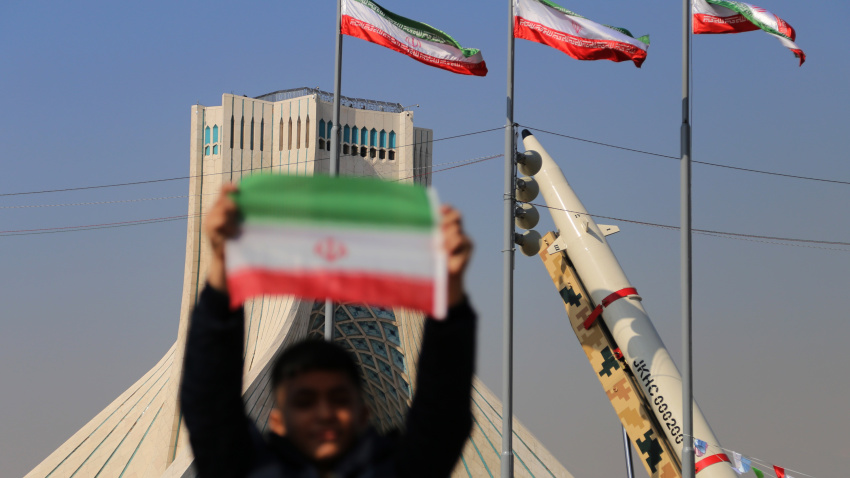 Un niño iraní sostiene una bandera iraní cerca de los misiles de fabricación iraní en la plaza Azadi (libertad) de Teherán, mientras la gente se reúne para conmemorar el 45 aniversario de la revolución islámica en Teherán.