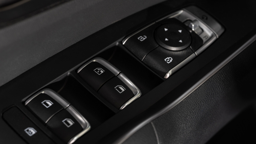 Panel de la puerta del conductor con botones para cerrar el coche y bajar las ventanillas.