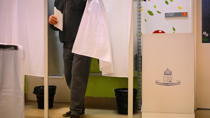 Un hombre sale de la cabina de votación para emitir su voto durante las elecciones generales.