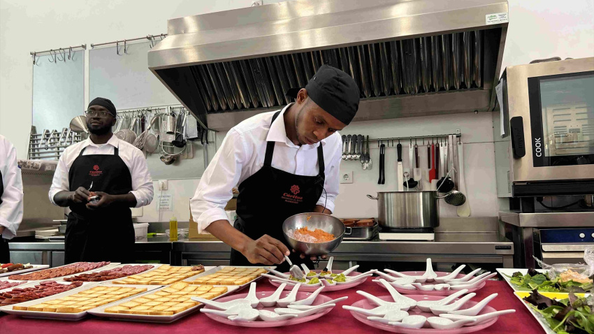Una persona migrante trabaja en una cocina