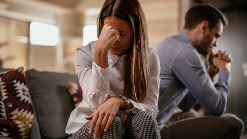 Pareja discute en el sofá de su casa