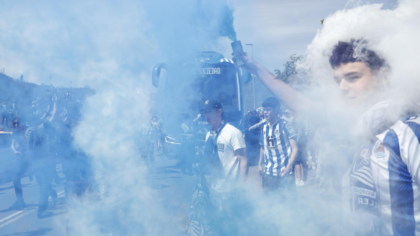 Aficionados de la Real envueltos en humo de las bengalas para animar el equipo txuri urdin. EFE/Juan Herrero.