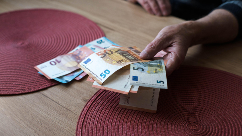 Un jubilado cuenta dinero, billetes de euro.