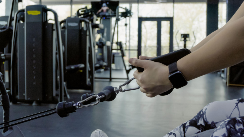 Persona levantando una barra en un gimnasio