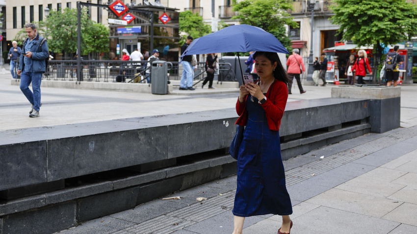 Una muejr camina con su paraguas por las calles de Madrid