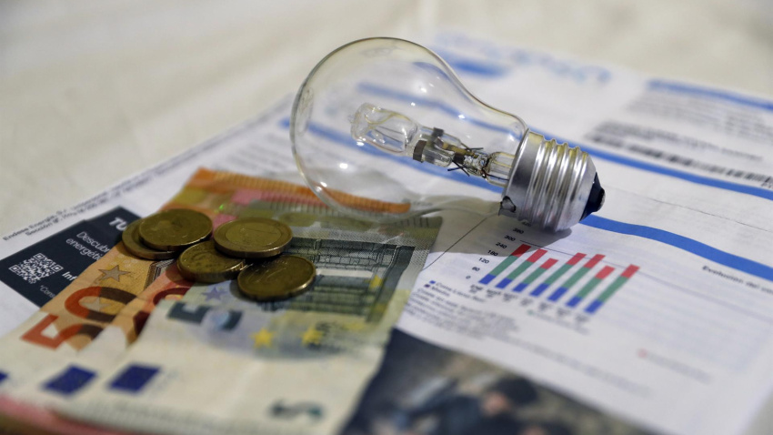 Una factura de la luz con billetes y monedas de Euro