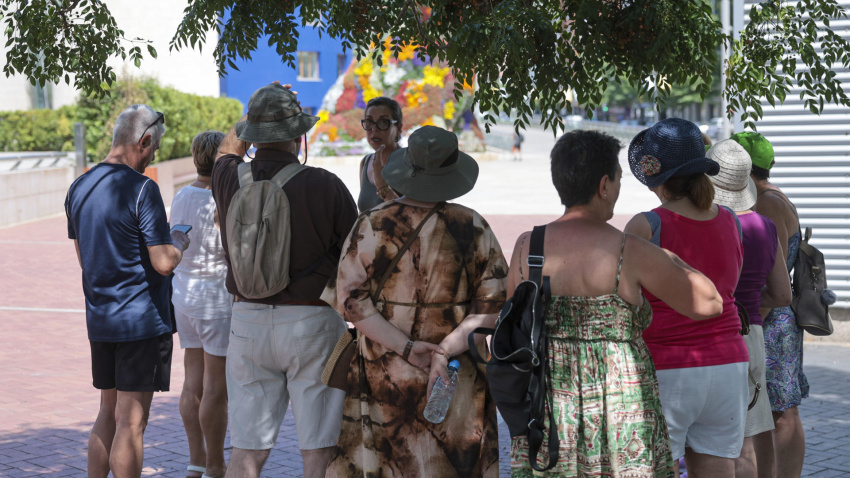 Turistas en la sobra se protegen del fuerte calor en Bilbao