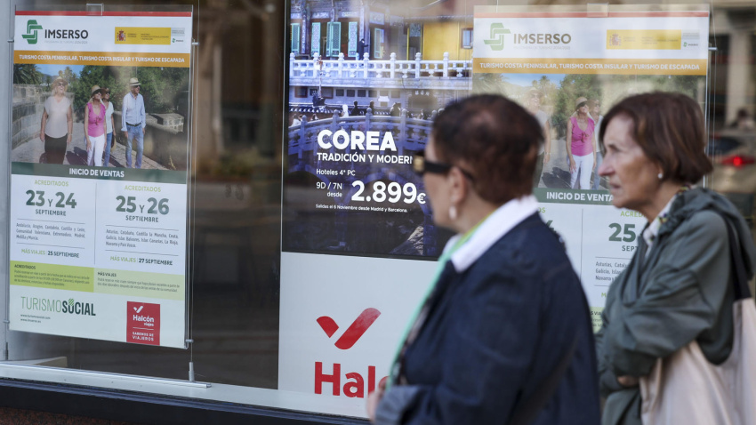 Dos jubiladas pasan por delante de una agencia de viajes donde anuncia viajes del Imserso