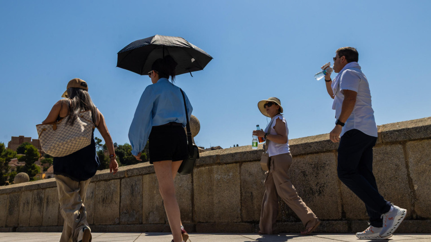 Los turistas se protegen del sol con paraguas y se hidratan este miércoles en Toledo