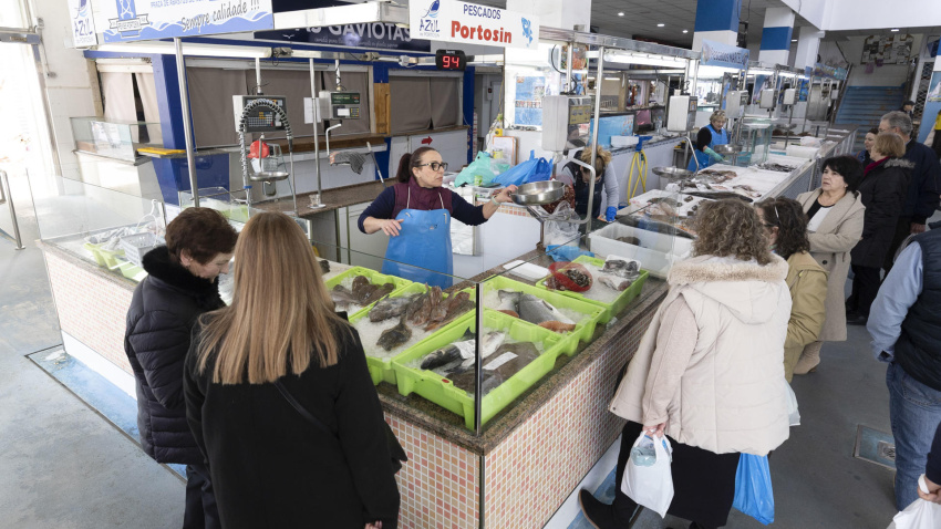 Varias clientas rodean una pescadería en el mercado de Noia