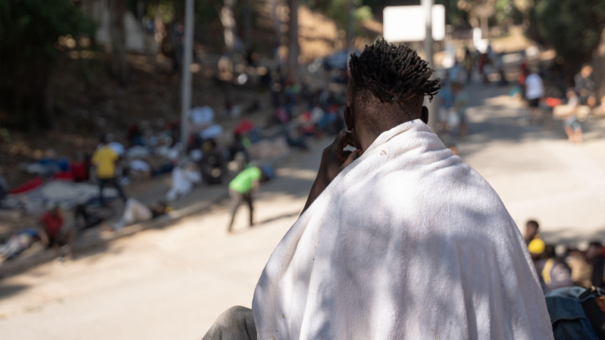 Migrantes, en su mayoría procedentes del África subsahariana, esperan en el CETI (Centro Temporal de Inmigración) de Ceuta tras días sin comida ni agua, al no poder acceder a las instalaciones, que se encuentran superpobladas. Además, reciben asistencia de una ONG para presentar solicitudes de asilo, ya que muchos buscan protección tras huir de conflictos armados.