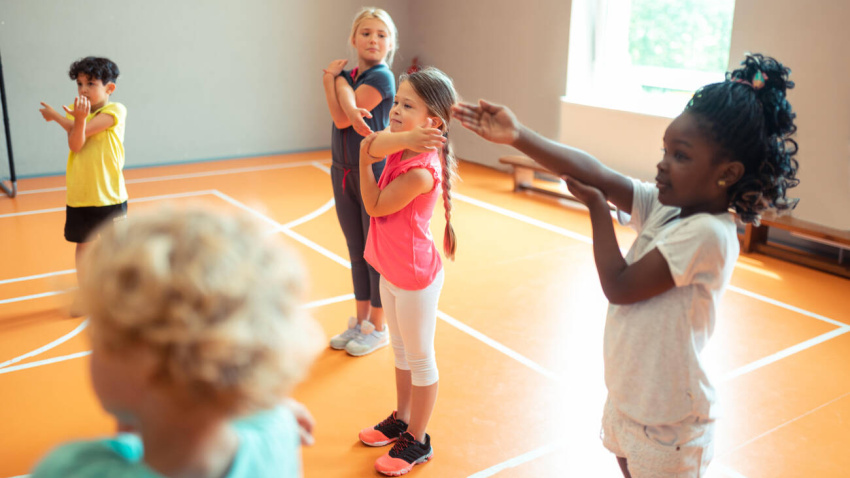 W2H807 Elementary school children working out at sports lesson.
