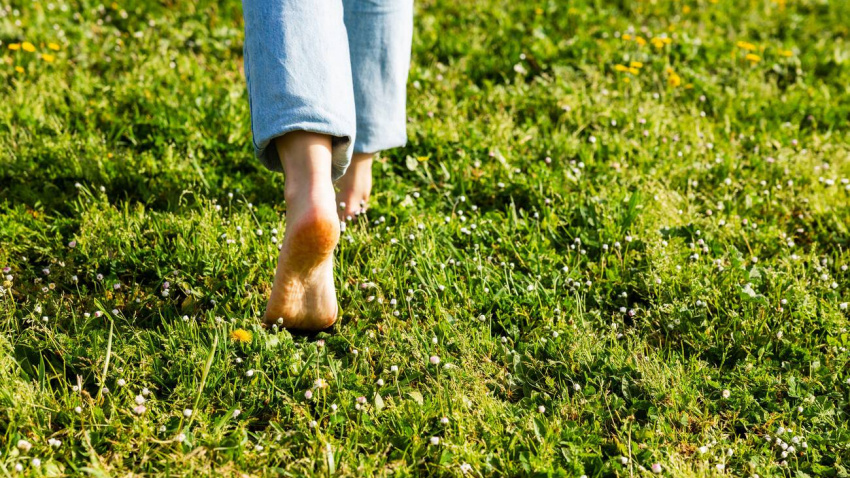 Persona andando descalza sobre el cesped