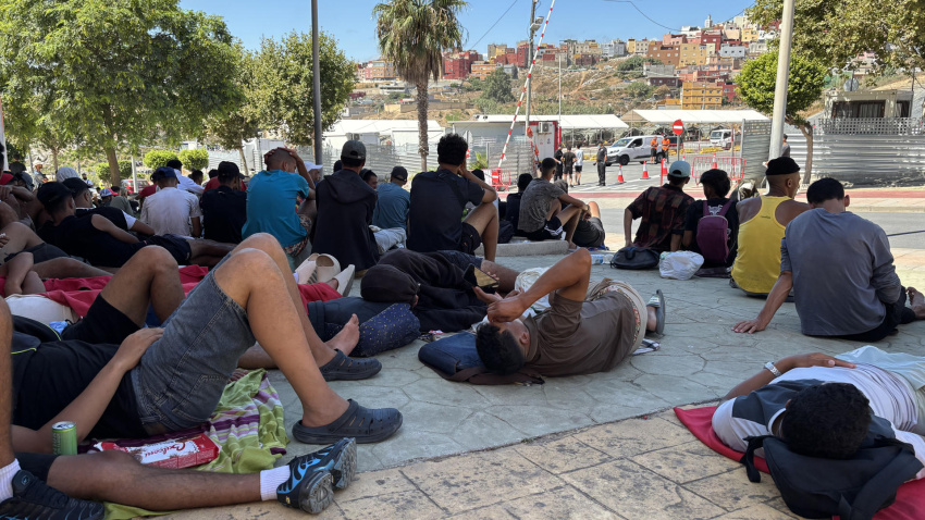 Varios migrantes congregados en los alrededores del Embolsamiento Loma Colmenar, de los espacios habilitados por el Gobierno para la estancia temporal de migrantes, este sábado en Ceuta. EFE/ Laura Rincón