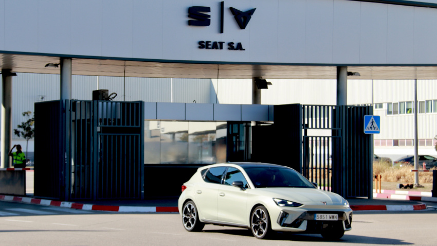 Entrada principal de la fábrica Seat de Martorell, con un vehículo Cupra saliendo de las instalaciones.