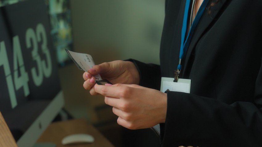 Unrecognizable woman concierge worker hotel reception give flight ticket check passport registration service tourist traveler passenger man arrive travel business trip tourism airport terminal control. High quality 4k footage
