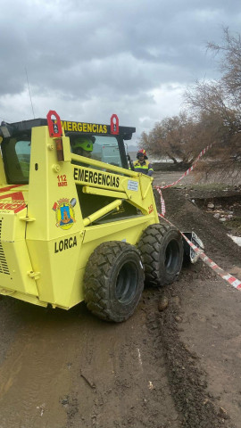 Un vehículo del servicio de Emergencias de Lorca retirando barro de una carretera