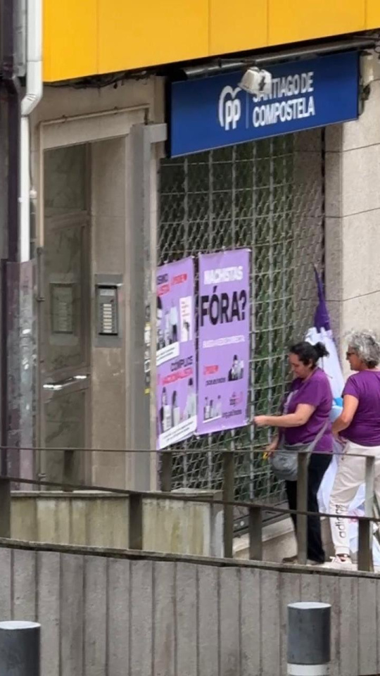 Varias personas colocan carteles a las puertas de la sede del PP de Santiago este pasado 25 de junio
