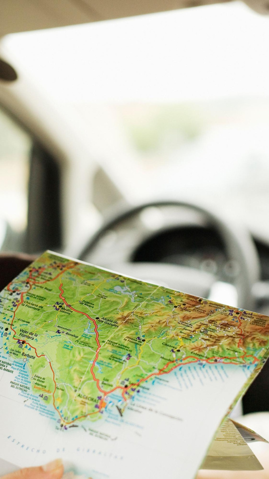 Un hombre mira un mapa en un coche en España, imagen recurso