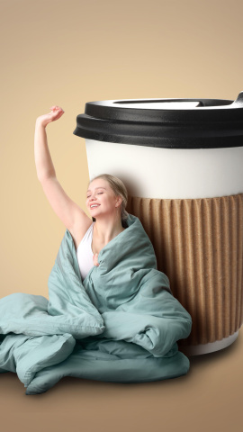 Joven envuelta en una manta y con una taza grande de café