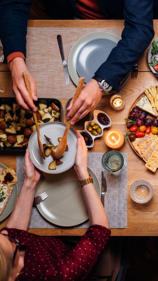 From above photo of group of friends enjoys eating delicious vegetarian food during a dinner celebration.