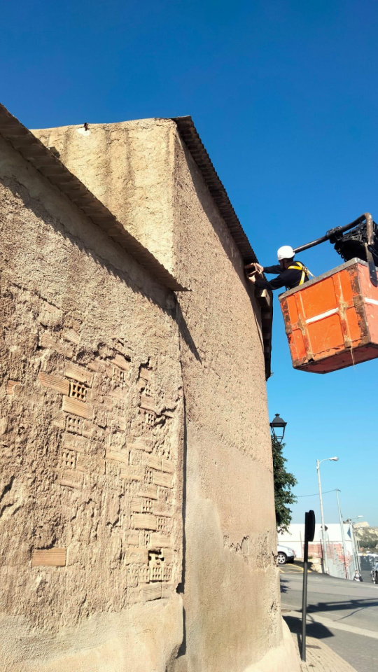 Un operario revisa una de las cajas nido en un edificio en Lorca