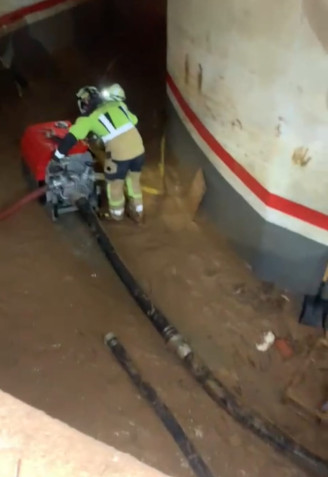 Bomberos vascos achicando agua en un garaje de Alfafar