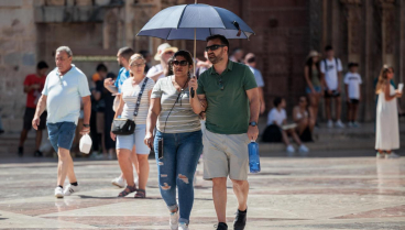 Dos personas con un paraguas para protegerse por el calor